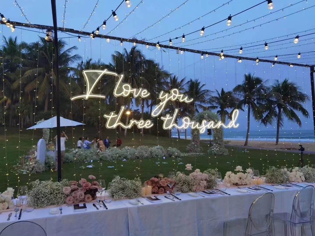 outdoor wedding neon sign shows I love you three thousand