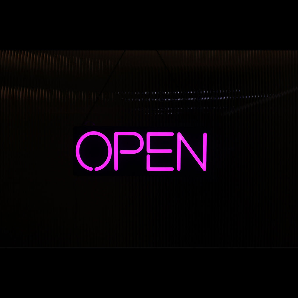 a lighting hanging hot pink open neon sign
