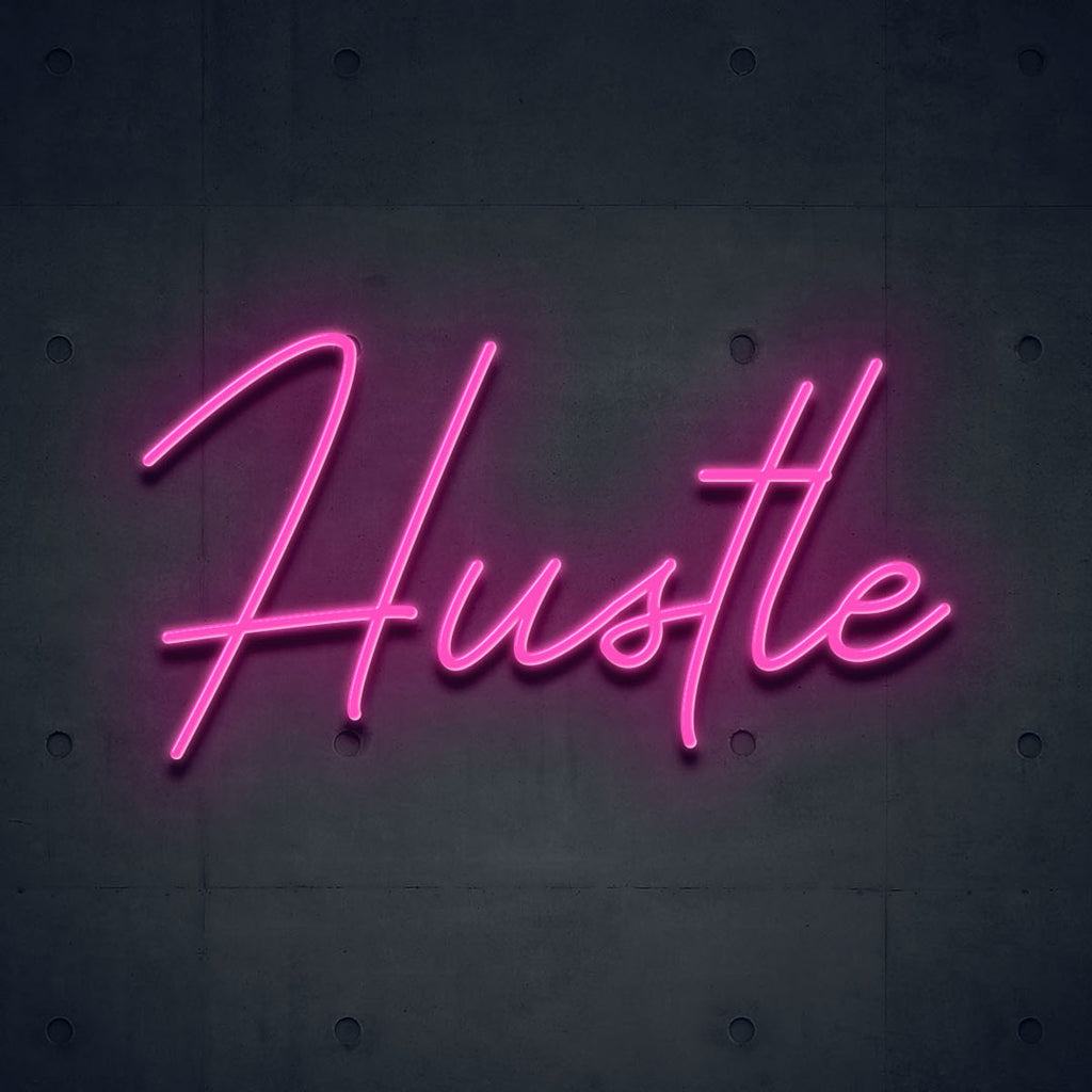 pink led neon sign of text hustle
