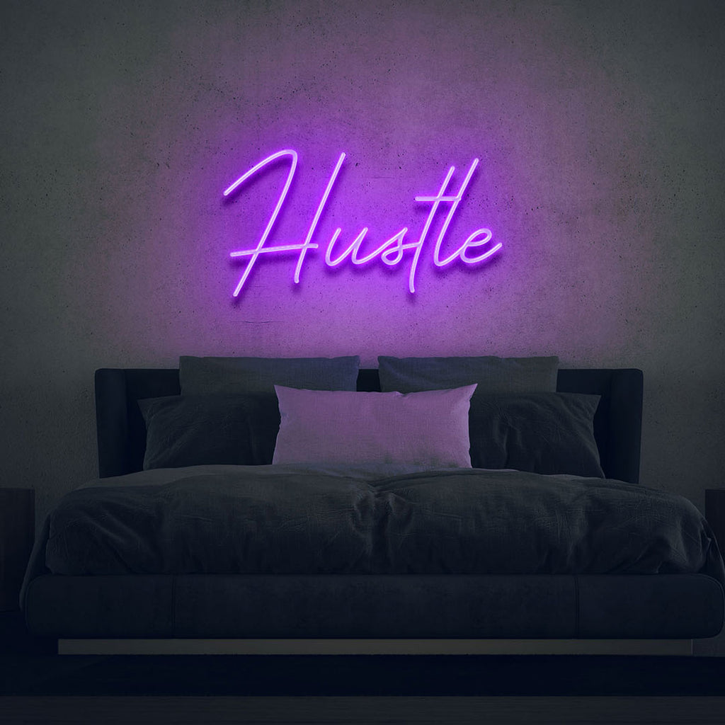 purple led neon sign of text hustle